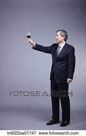 middle aged man in a business suit tossing a wine View Large Photo Image Stock Photo - middle aged man in a business suit tossing a wine. Fotosearch
