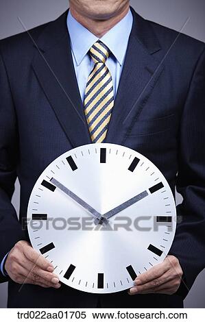 middle aged man in a business suit holding a clock View Large Photo Image Stock Photography - middle aged man in a business suit holding a clock. Fotosearch