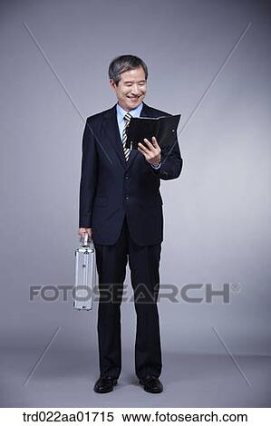 middle aged man in a business suit holding a suitcase View Large Photo Image Stock Photography - middle aged man in a business suit holding a suitcase. Fotosearch