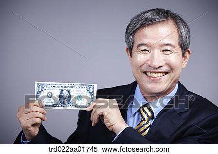 middle aged man in a business suit holding a dollar View Large Photo Image Stock Photography - middle aged man in a business suit holding a dollar. Fotosearch