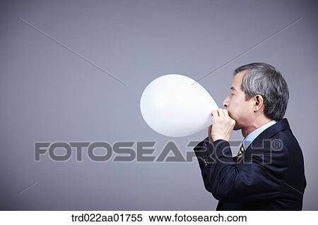 middle aged man in a business suit blowing balloon View Large Photo Image Stock Photography - middle aged man in a business suit blowing balloon. Fotosearch