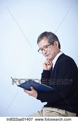 Stock Photo - middle aged man reading a book. Fotosearch