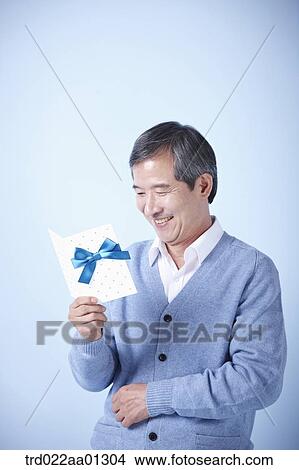 middle aged man reading a card View Large Photo Image Picture - middle aged man reading a card. Fotosearch