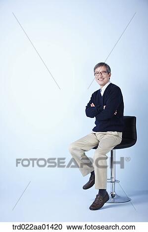 middle aged man sitting on a chair View Large Photo Image Stock Image - middle aged man sitting on a chair. Fotosearch