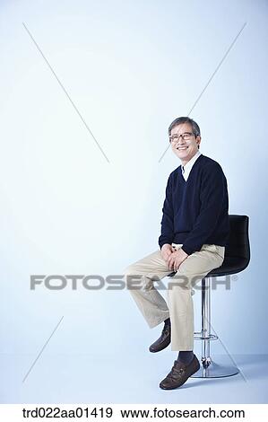 middle aged man sitting on a chair View Large Photo Image Stock Photo - middle aged man sitting on a chair. Fotosearch