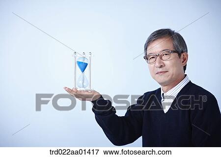 middle aged man with sand hourglass View Large Photo Image Stock Photo - middle aged man with sand hourglass. Fotosearch