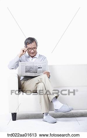 middle aged sitting on a couch reading a newspaper View Large Photo Image Stock Image - middle aged sitting on a couch reading a newspaper. Fotosearch