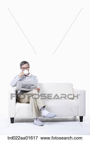middle aged sitting on a couch reading a newspaper View Large Photo Image Stock Photo - middle aged sitting on a couch reading a newspaper. Fotosearch