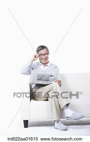middle aged sitting on a couch reading a newspaper View Large Photo Image Stock Photography - middle aged sitting on a couch reading a newspaper. Fotosearch