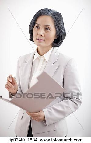 Picture - middle aged woman in business suit holding a folder. Fotosearch