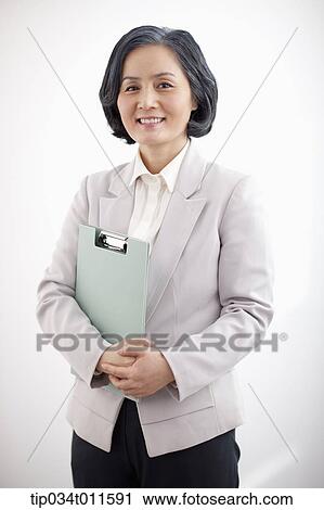 Stock Image - middle aged woman in business suit holding a folder. Fotosearch