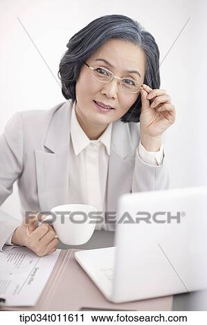 middle aged woman in business suit using a laptop View Large Photo Image Stock Image - middle aged woman in business suit using a laptop. Fotosearch