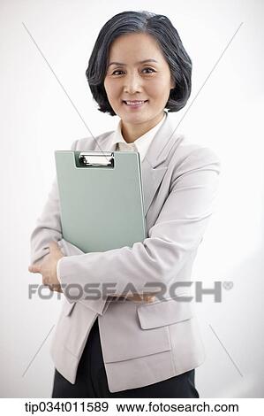 middle aged woman in business suit holding a folder View Large Photo Image Stock Photo - middle aged woman in business suit holding a folder. Fotosearch