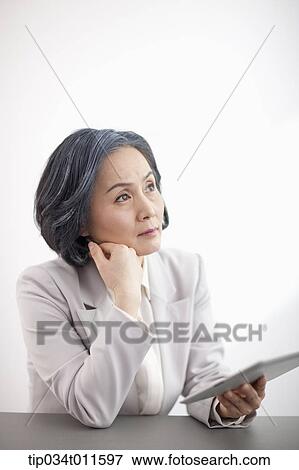 middle aged woman in business suit using tablet PC View Large Photo Image Stock Photo - middle aged woman in business suit using tablet PC. Fotosearch