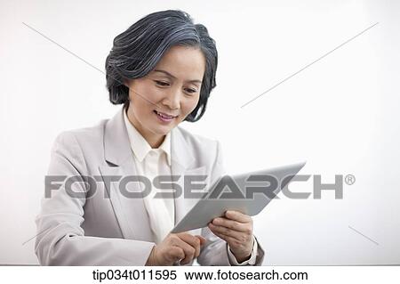 middle aged woman in business suit using tablet PC View Large Photo Image Stock Photography - middle aged woman in business suit using tablet PC. Fotosearch