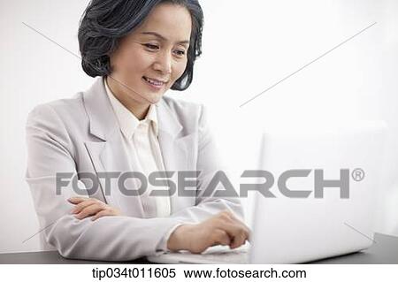 middle aged woman in business suit using a laptop View Large Photo Image Stock Photography - middle aged woman in business suit using a laptop. Fotosearch