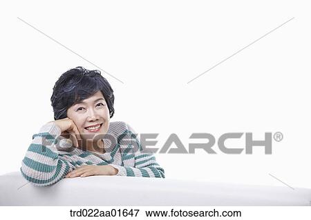 middle aged woman leaning on a couch View Large Photo Image Stock Photo - middle aged woman leaning on a couch. Fotosearch