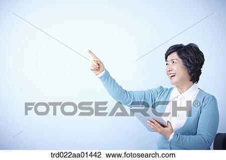 middle aged woman pointing while using tablet PC View Large Photo Image Stock Image - middle aged woman pointing while using tablet PC. Fotosearch