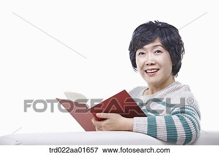 middle aged woman reading a book on a couch View Large Photo Image Stock Photo - middle aged woman reading a book on a couch. Fotosearch