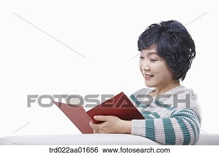 middle aged woman reading a book on a couch View Large Photo Image Stock Photograph - middle aged woman reading a book on a couch. Fotosearch