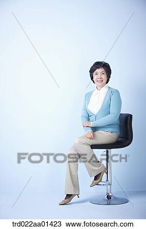 middle aged woman sitting on a chair View Large Photo Image Stock Image - middle aged woman sitting on a chair. Fotosearch