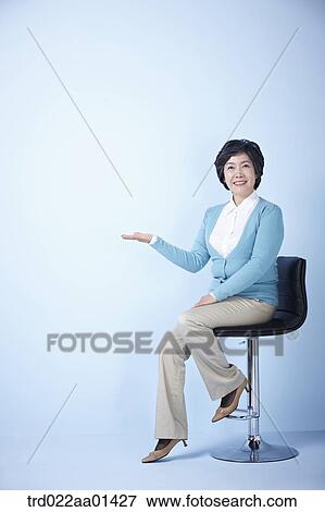 middle aged woman sitting on a chair View Large Photo Image Stock Photo - middle aged woman sitting on a chair. Fotosearch