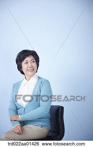 middle aged woman sitting on a chair View Large Photo Image Stock Photograph - middle aged woman sitting on a chair. Fotosearch