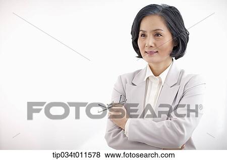Stock Photo - middle aged woman standing with arms crossed. Fotosearch
