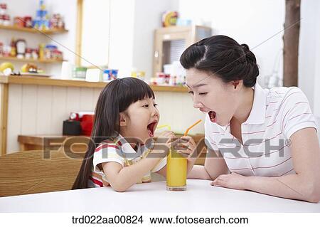 mother and daughter drinking juice together View Large Photo Image Picture - mother and daughter drinking juice together. Fotosearch
