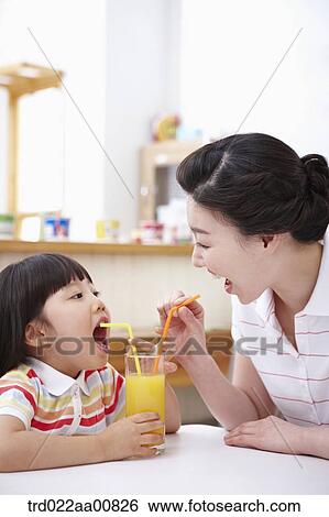 mother and daughter drinking juice together View Large Photo Image Stock Photograph - mother and daughter drinking juice together. Fotosearch