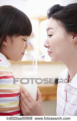 Stock Photo - mother and daughter drinking milk together. Fotosearch