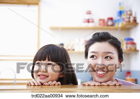 mother and daughter hiding behind table View Large Photo Image Picture - mother and daughter hiding behind table. Fotosearch