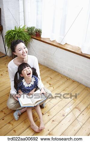 mother and daughter looking up while reading a book View Large Photo Image Stock Image - mother and daughter looking up while reading a book. Fotosearch