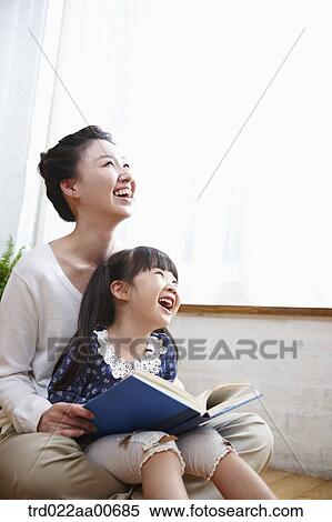mother and daughter looking up while reading a book View Large Photo Image Stock Photography - mother and daughter looking up while reading a book. Fotosearch