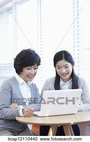 Stock Image - mother and daughter sharing a laptop. Fotosearch