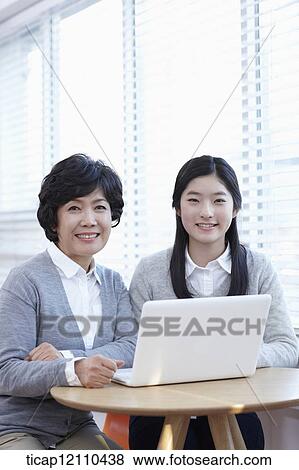 mother and daughter sharing a laptop View Large Photo Image Stock Photo - mother and daughter sharing a laptop. Fotosearch
