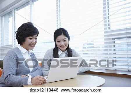 Stock Photograph - mother and daughter sharing a laptop. Fotosearch