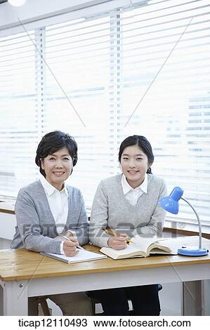 Stock Image - mother and daughter sitting together in the classroom. Fotosearch