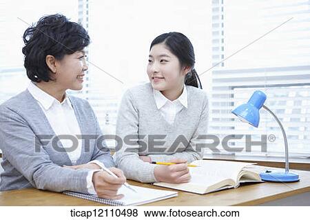Stock Photo - mother and daughter sitting together in the classroom. Fotosearch