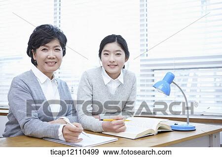 Stock Photo - mother and daughter sitting together in the classroom. Fotosearch