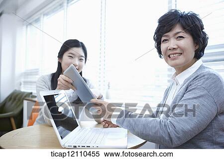Stock Photography - mother and daughter using laptop and tablet PC. Fotosearch