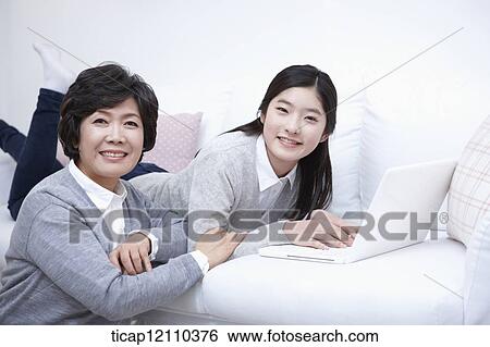 mother next to daughter using laptop on the bed View Large Photo Image Stock Photograph - mother next to daughter using laptop on the bed. Fotosearch