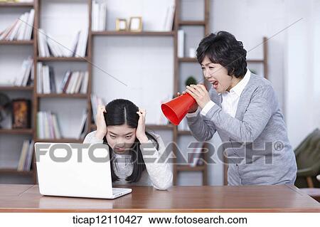 Stock Photo - mother scolding daughter with megaphone. Fotosearch