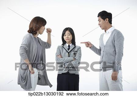 Stock Image - parents scolding at a daughter with a school uniform. Fotosearch