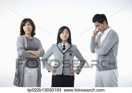 Stock Image - parents scolding at a daughter with a school uniform. Fotosearch