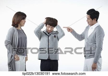 Stock Image - parents scolding at a son with a school uniform. Fotosearch