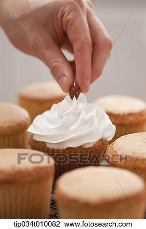 putting almond on cup cake View Large Photo Image Stock Image - putting almond on cup cake. Fotosearch