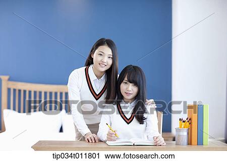students in uniform at a desk studying together View Large Photo Image Stock Image - students in uniform at a desk studying together. Fotosearch