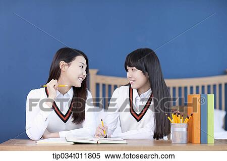 Stock Photography - students in uniform at a desk studying together. Fotosearch