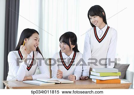 Stock Photography - students in uniform at a desk studying together. Fotosearch